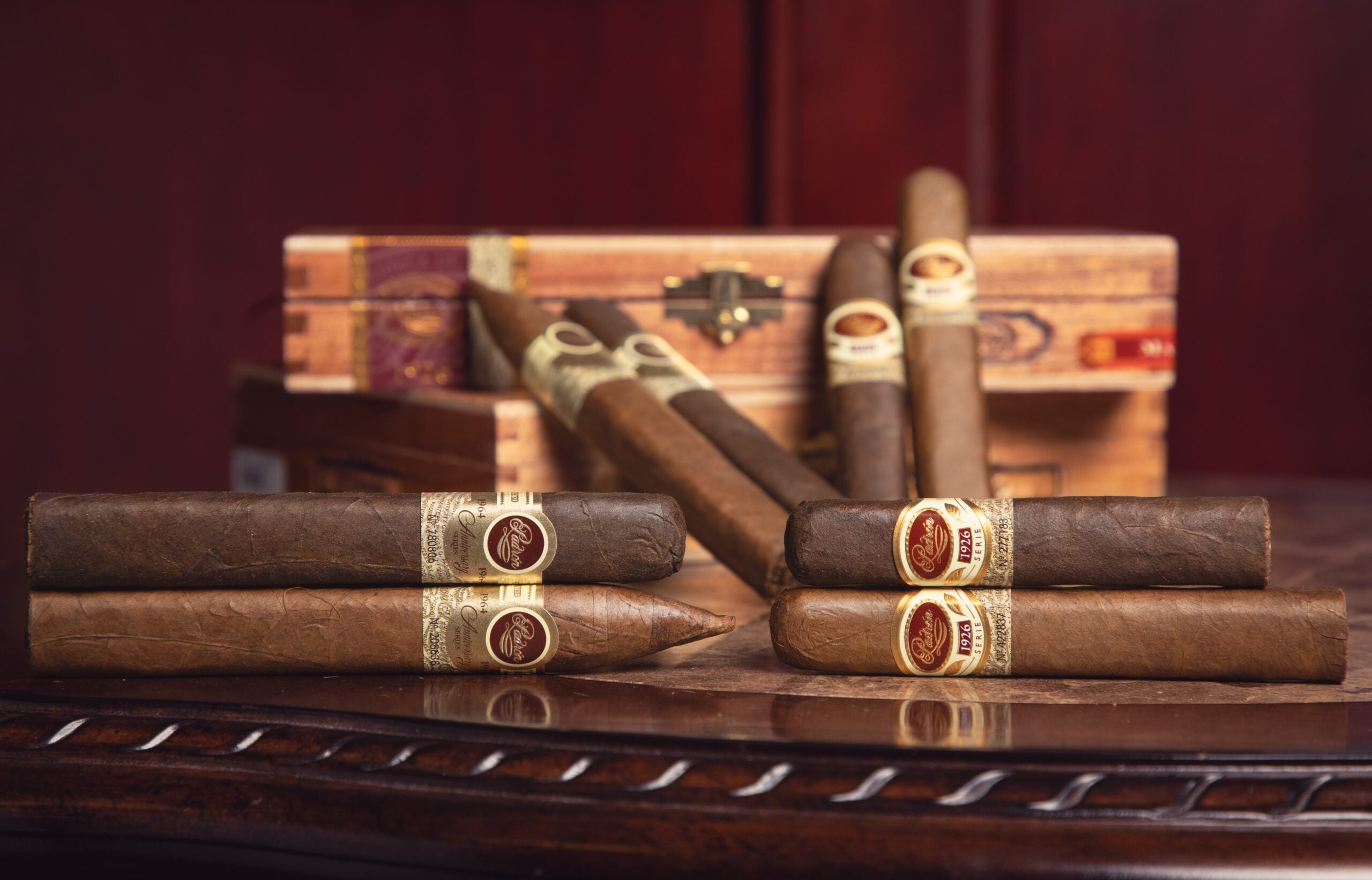 set up shot of padron 1926 and 1964 anniversari cigars displayed with their boxes